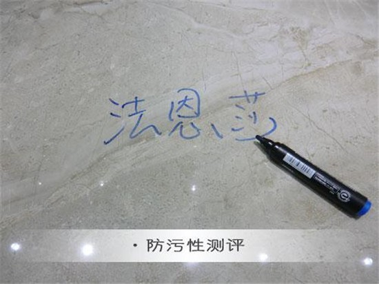 小编用蓝色彩笔在威尼时光瓷砖表面书写“法恩莎”字样，以此测评该款瓷砖的防污性能。