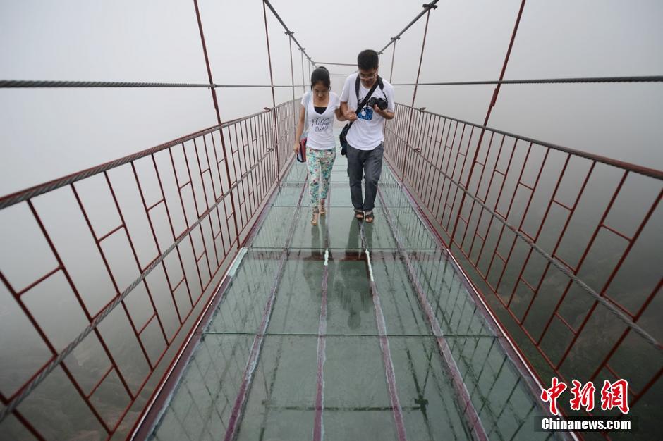 9月29日，多位游客走上摇晃的玻璃吊桥，吓得不敢动弹。