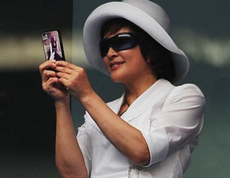 刘晓庆助阵中网 握手机拍照