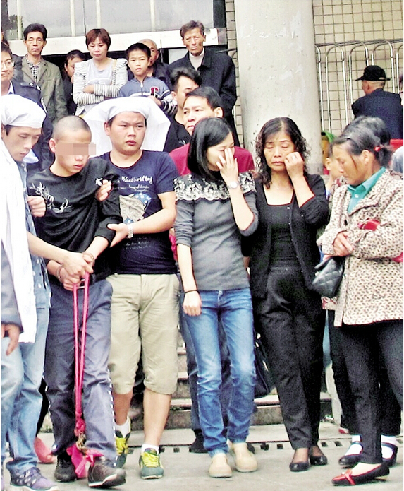 图为：前日，一名在湖北江北监狱服刑的重刑犯（左二）在狱警的监护下，前往石首市殡仪馆，送别因车祸遇难的父亲。