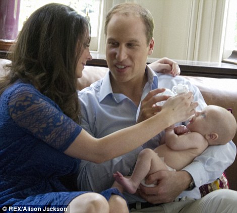 威廉王子夫妇坐在沙发上，喂乔治小王子喝奶粉。