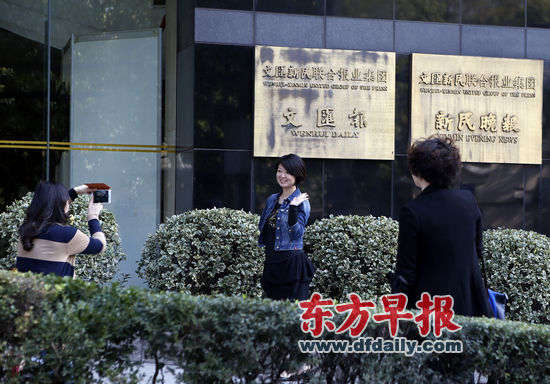 昨日下午，文汇新民联合报业集团大楼前，工作人员拍照留念。 早报记者赵昀图