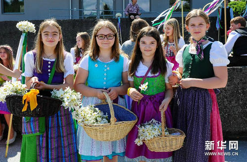5月31日,在奥地利中部小城巴特奥赛,身着奥地利传统服装的小姑娘为