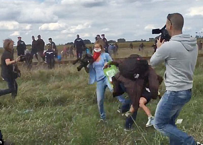 警察追捕时，女记者故意绊倒抱孩难民