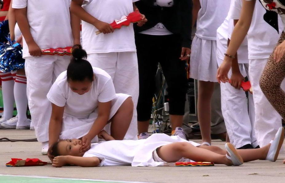 因为天气太过炎热,表演舞蹈的小演员不慎中暑晕倒在地.