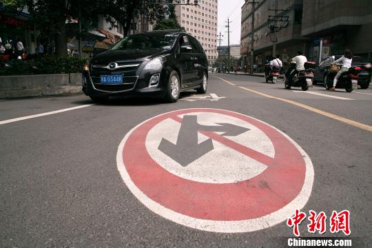 汽车从躺在地面上的禁行标志旁经过.张浪