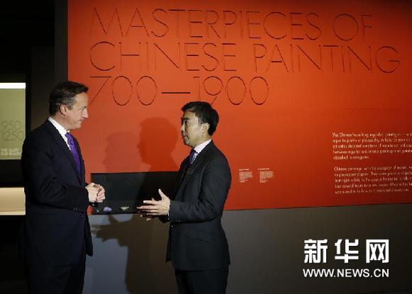 11月28日，在伦敦维多利亚和艾尔伯特博物馆，英国首相卡梅伦（左）聆听中国藏品高级研究员张弘星的介绍。新华网图片 王丽莉 摄