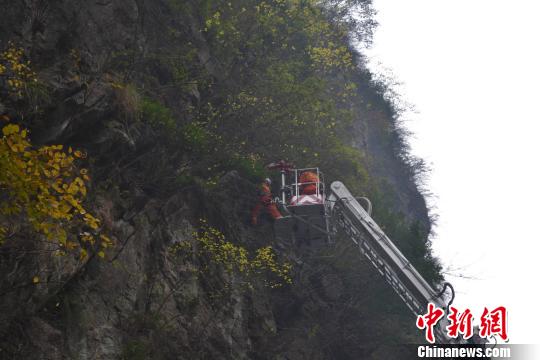 图为消防官兵在半山腰救援男子遗体。　宋林汶　摄