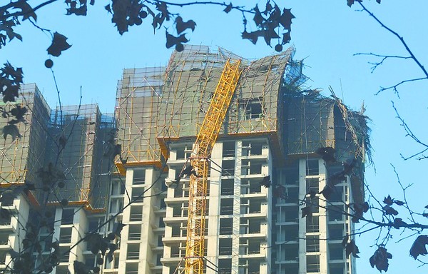 12月11日14时30分,石家庄市内一处建筑工地内的一个高层塔吊突然发生坍塌,倾斜的塔吊向北砸在了正在建设中的楼体上,而塔吊的起重臂发生折断,坠落在地面上。由于事发现场紧挨着东风西路小学,此事引起了家长们的担心。施工工地的一位工作人员称,事故未造成人员伤亡。 本报记者 孟宇光/摄