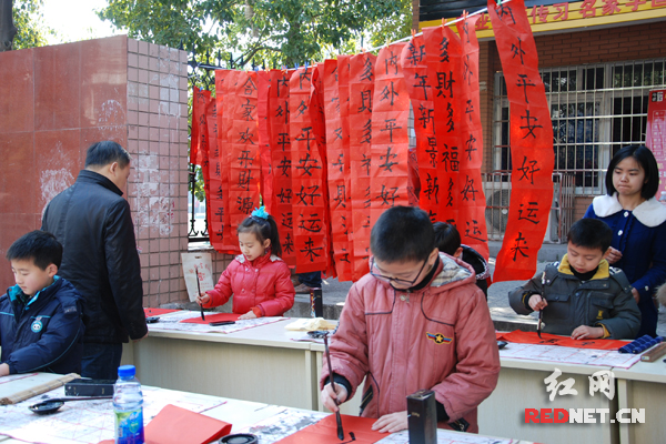 书法培训班小学生给小区居民免费写春联(图)