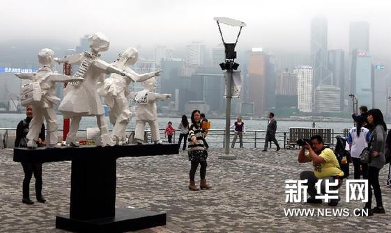 2月28日，游人在香港艺术馆旁参观朱铭的大型雕塑《第三代》。新华网图片 李鹏 摄