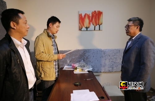 　　办案人员向周耀(右)宣布逮捕决定。吴贻伙 摄