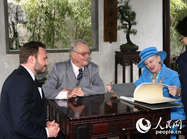 丹麦女王玛格丽特二世和亨里克亲王在凉亭内翻看拙政园画册。（摄影：彭忠民）