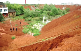 4月26日，双峰县，彭满秀家的房子，坐落在“大坑”之中，坑外遍布工厂。　图/记者袁树勋