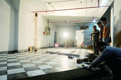 (5月12日，万国城小区二期四栋地下车库约200平方米的地方正在改造成物业公司的食堂。记者 唐俊 摄)