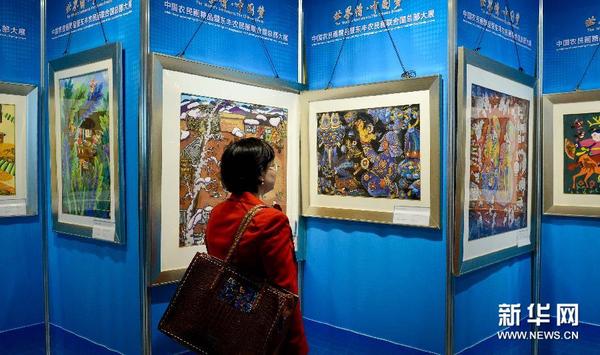 5月21日，参观者在纽约联合国总部举行的“世界情&middot;中国梦”中国农民画精品展上观看画作。