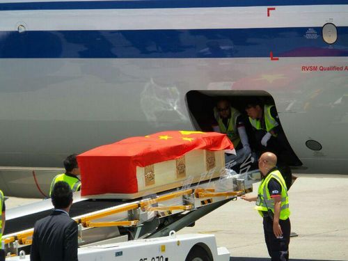 马万祺灵柩盖上国旗,由警员护送登上灵车。