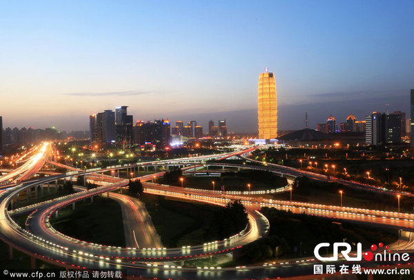 　　5月28日晚，河南省郑州市，站在金水路与通泰路交叉口的高楼顶端向前望去，郑州会展宾馆如同一个巨大的金黄色“玉米棒”矗立在郑东新区CBD中央，成为一道靓丽风景。　图片来源：卢键/CFP