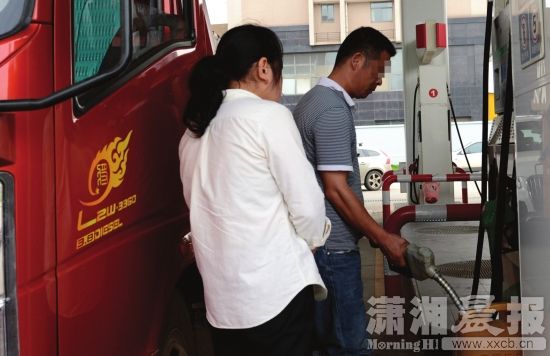 5月29日，长沙香樟东路与体院路交会处，货车司机在附近一家加油站用散装塑料桶加油。图/潇湘晨报记者 陈勇