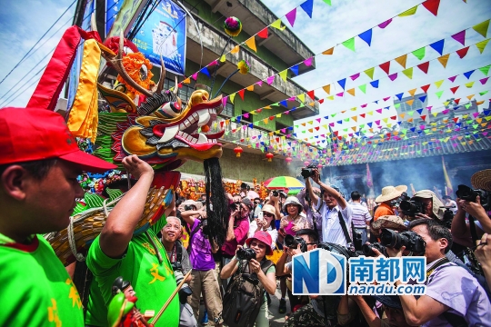 龙舟队员将龙头抬进龙母庙祈福，被众多摄影爱好者围得水泄不通。