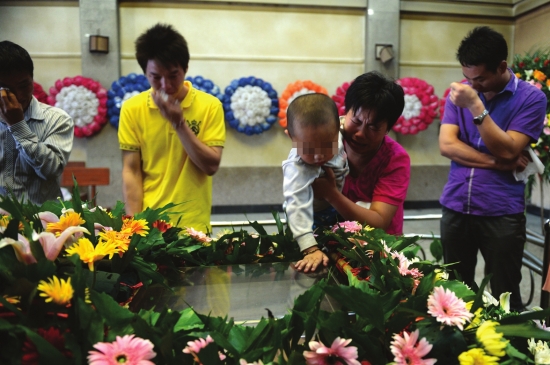 6月5日，娄底市殡仪馆，殷晓非的亲人悲痛不已，他快3岁的儿子还不懂事，看着父亲的遗体。图/记者辜鹏博