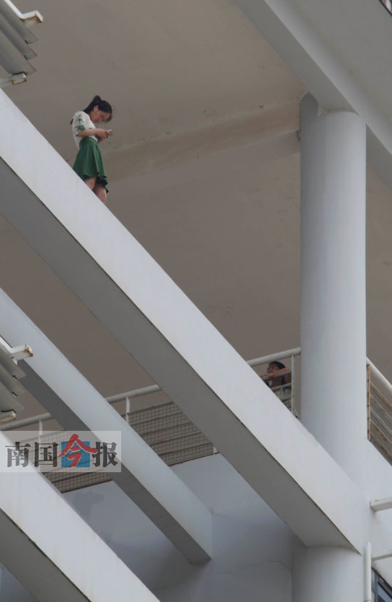 时间过去了近4个小时,这名学生还在悬空横梁上玩手机。