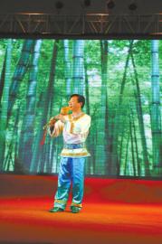 中国农业银行南充分行副行长强勇表演独奏葫芦丝。