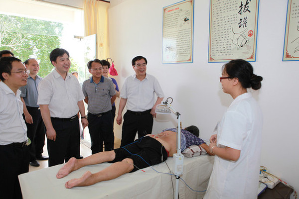 李国坚（右2）勉励那满镇中心卫生院医务人员要充分发挥中医民族医药的优势服务群众。