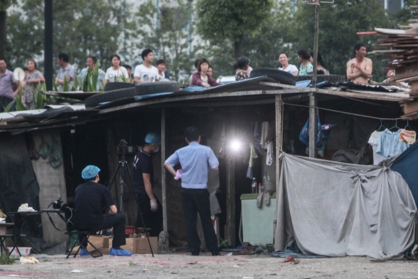 7月20日，杭州余杭区一简易棚租房内的两名女孩死亡，市民在棚后围观。