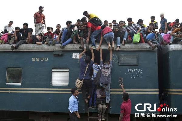 　　当地时间2014年7月27日，孟加拉国达卡，穆斯林爬上拥挤的火车坐在车顶，准备回家过开斋节，人潮爆满，火车里外上下都是人。图片来源：AM Ahad/东方IC