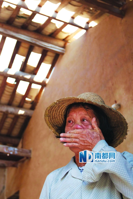 7月23日,海南省文昌市翁田镇下 村,83岁的张芳莲在自家受损的房屋里,屋顶的瓦片被吹毁。