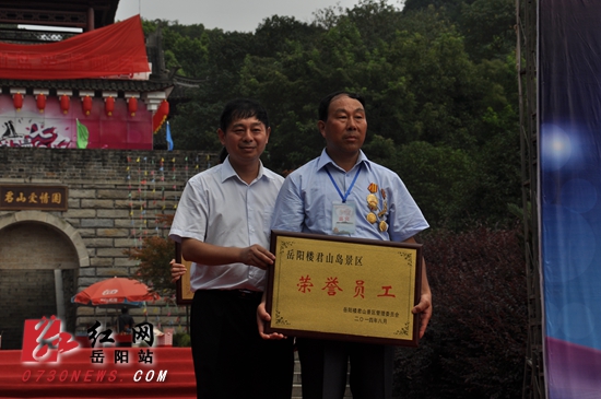 <?xml:namespace prefix = o />岳阳楼-君山岛景区主任黄二良（左）给“中国最美邮递员”钟子进颁发“爱心使者”、“荣誉员工”奖牌。