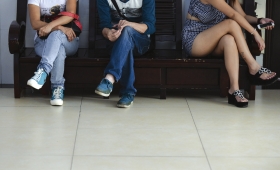 8月31日，长沙荷花园派出所，被找到的陈红秀（右）坐在凳子上，基本不和父母交流，她手上则拿着父亲刚刚送给她的苹果手机。图/记者辜鹏博