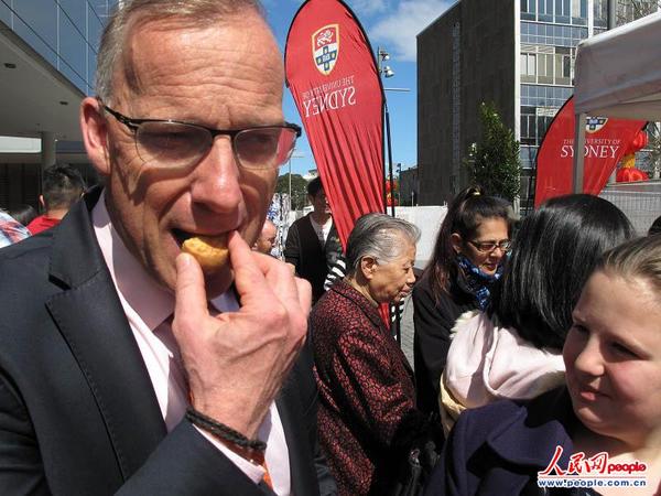 6.施迈克校长在活动现场品尝月饼（摄影 马小龙）