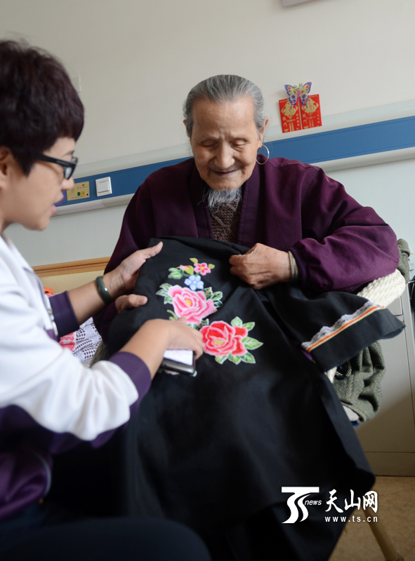 沙木老人在展示他自己制作和刺绣的哈尼族传统服饰