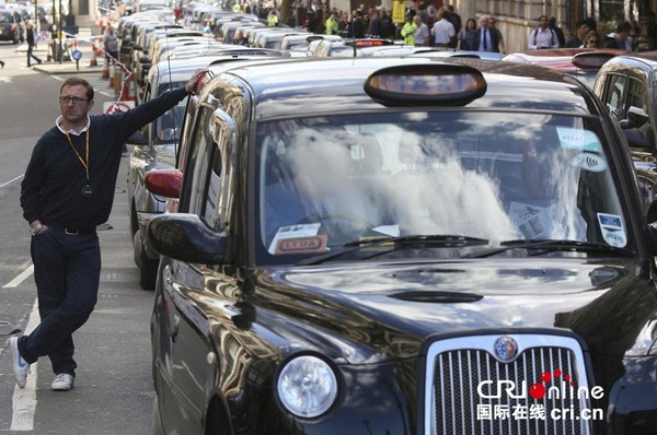 　　当地时间2014年9月24日，英国伦敦，出租车“排队”阻塞怀特霍尔街进行示威，抵制Uber打车应用和拼车行为。图片来源：CFP