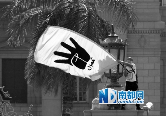 埃及一名穆尔西支持者挥舞着印有“四指”手势图案的旗帜，穆兄会推出的该手势指代埃及军方在Rabaaal-Adawiya清真寺的暴行，Rabaa在埃及是“四”的意思。