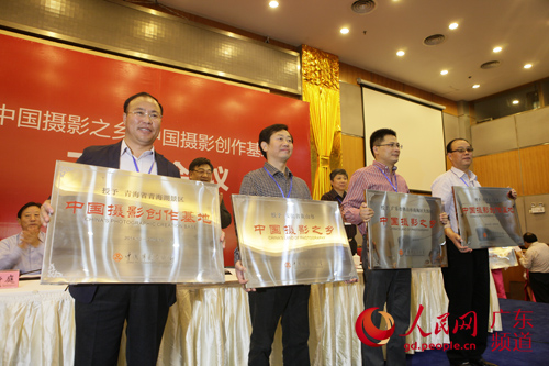 大沥镇文化站站长李智勇（右二）接受“中国摄影之乡”牌匾。