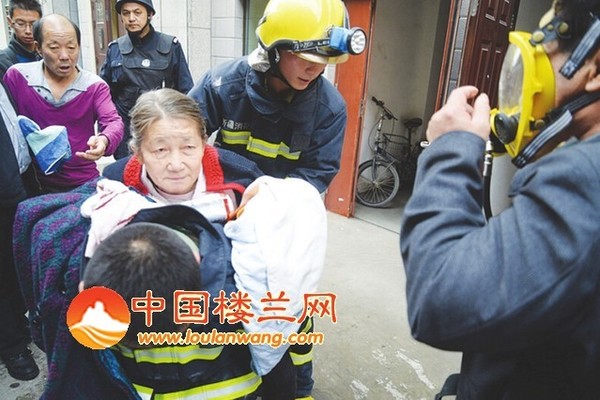消防员背着一位老人从大厦下来，空气呼吸器也给了另一位居民使用。