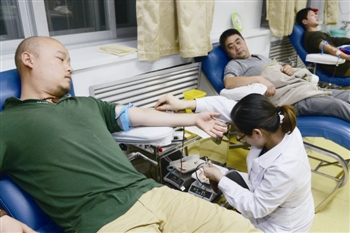 　　医护人员为献血者抽血。