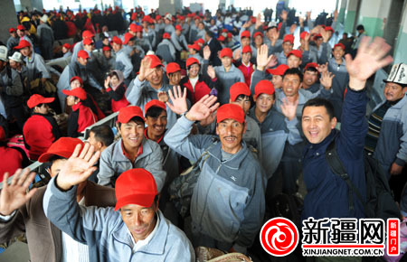 图为10月29日，在乌鲁木齐火车南站候车厅，即将检票进站的务工人员正在挥手道别。