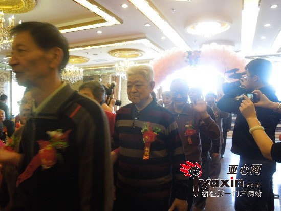 满头银发的老年夫妇排成一个长队，相持相携走过幸福门。