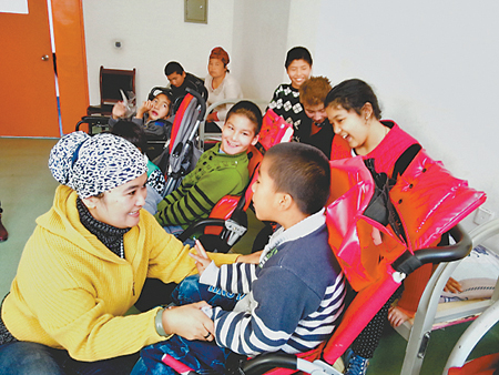 早热古丽·依米提和她的脑瘫孩子们在一起。（网络截图）