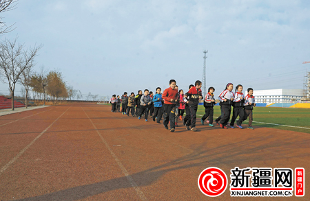 11月18日，在乌鲁木齐市103中学，学生们在新修建的塑胶运动场上跑步。