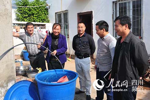 自来水来了,村民谢体琼笑得合不拢嘴(滕德银摄)