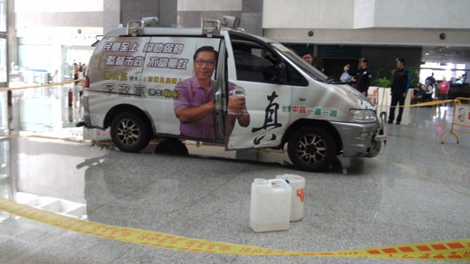 李姓议员候选人开车冲撞高雄市政府四维行政中心并泼洒汽油，汽油桶留在地上。图片来源：台湾《联合报》