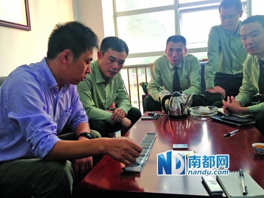 昨天下午,李树军博士(左一)来到东莞市消防局,为调查组成员解释电池自燃的原因。南都记者唐波摄