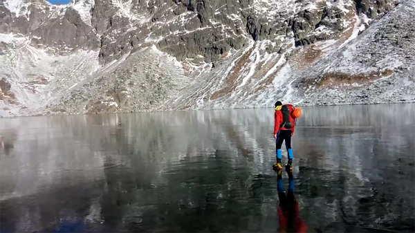 斯洛伐克徒步者行走高山湖冰面 晶莹剔透如履