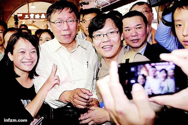 2014年11月28日,台北,市长候选人柯文哲走“民众路线”,在一个市场里与竞选活动的支持者摆Pose拍照。 (CFP/图)
