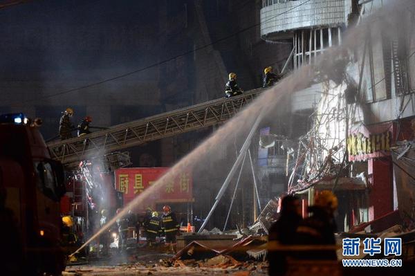 1月3日凌晨，消防战士在哈尔滨大火现场救援。新华社记者 王凯 摄